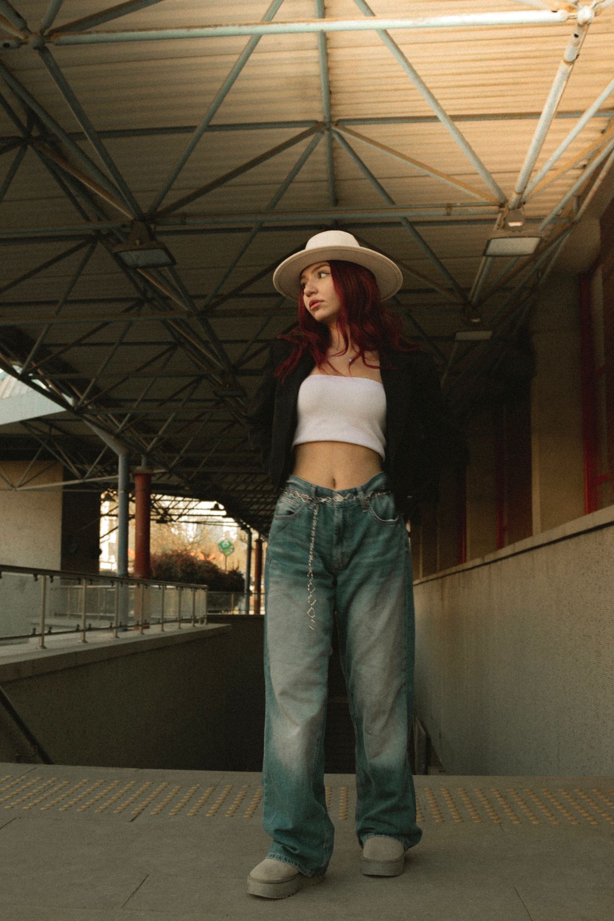 Woman in baggy jeans and a crisp button-down shirt with the front tucked in